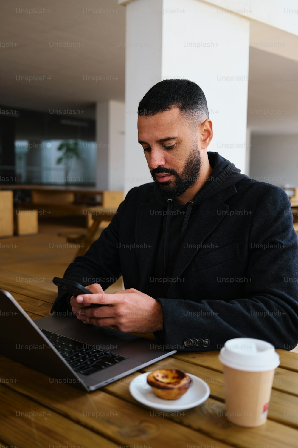ノートパソコンを使ってテーブルに座っている男性