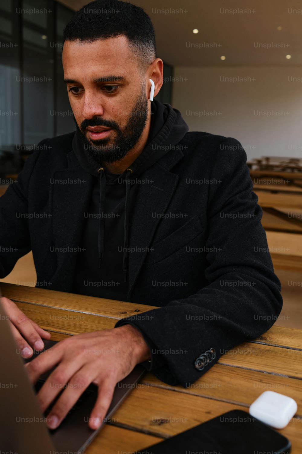 a man sitting at a table using a laptop computer