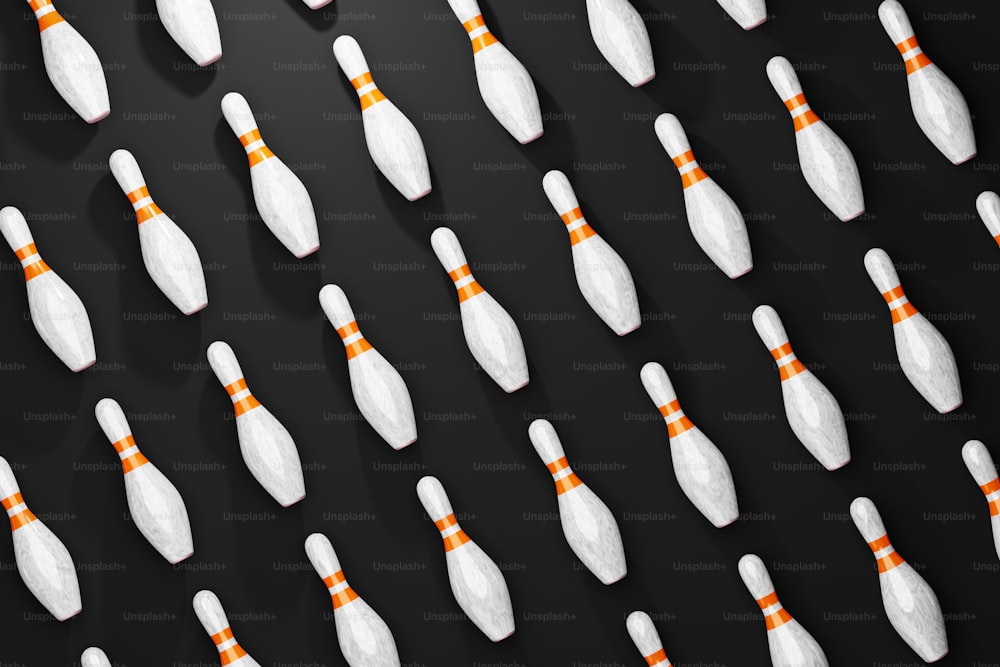 a bunch of white bowling pins lined up on a black surface