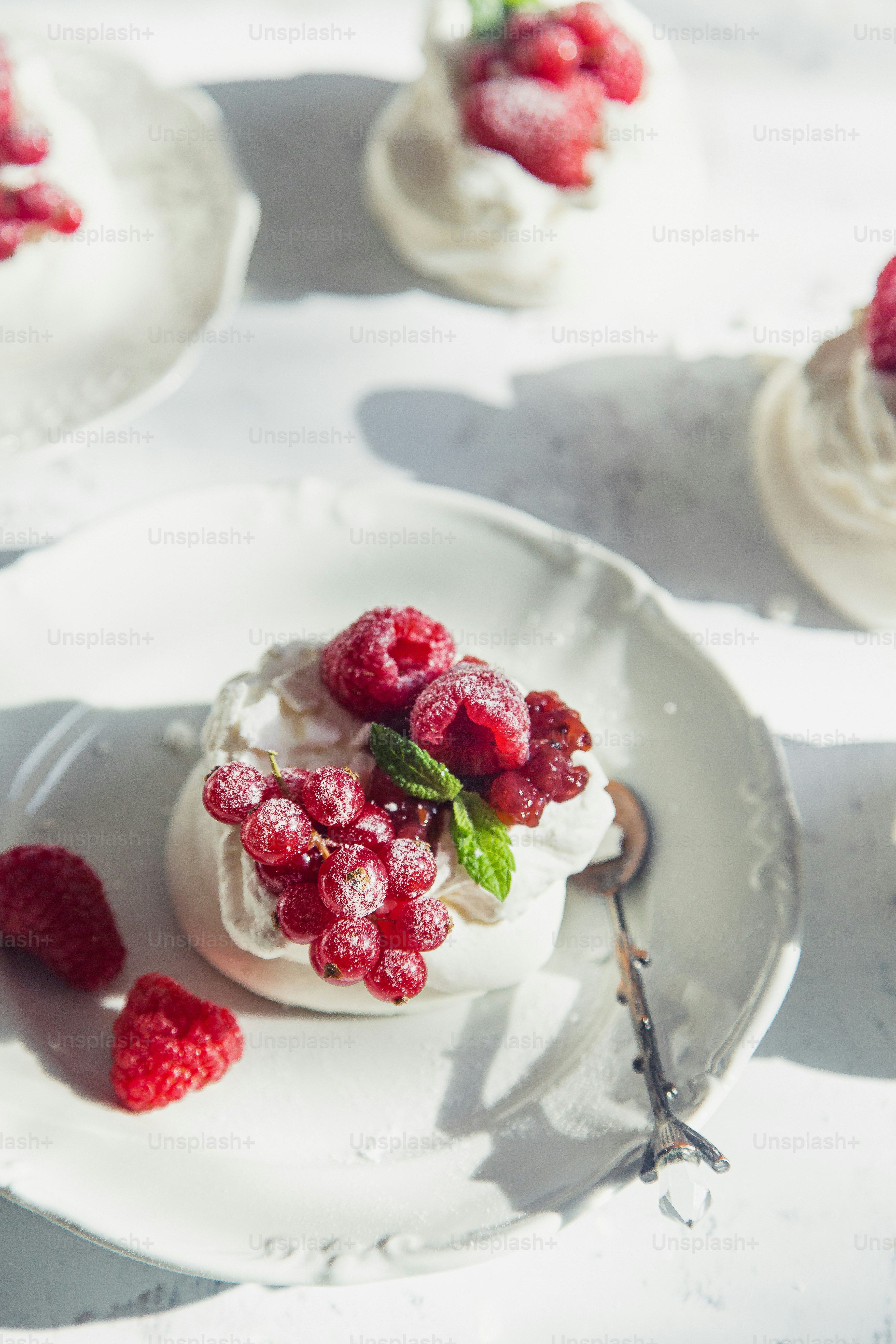 Un pequeño postre con frambuesas en un plato blanco