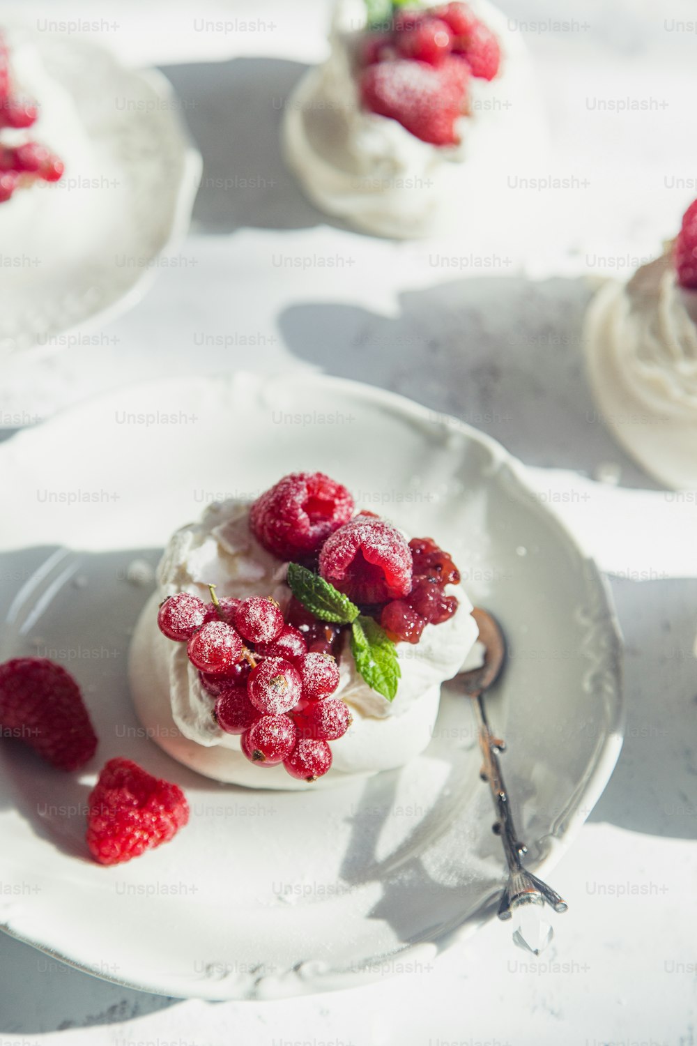 흰 접시에 나무 딸기를 곁들인 작은 디저트
