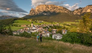 a couple of people standing on top of a lush green hillside