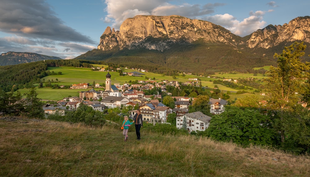 a couple of people standing on top of a lush green hillside