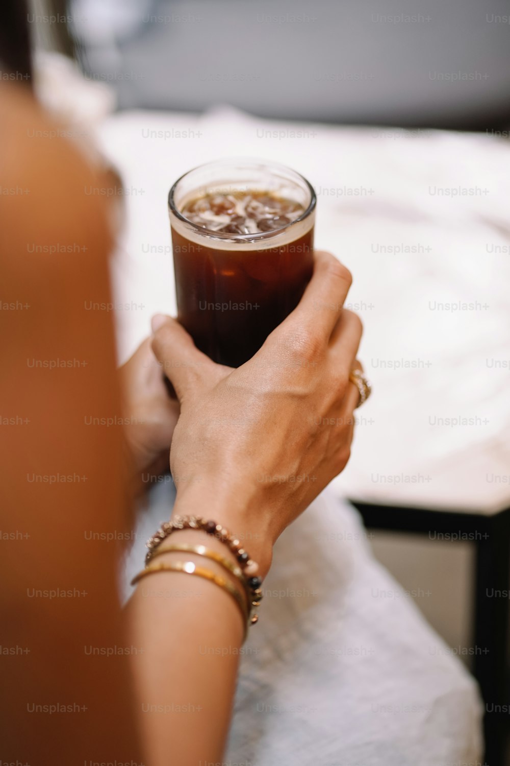 Eine Frau hält ein Glas kaltes Getränk in der Hand