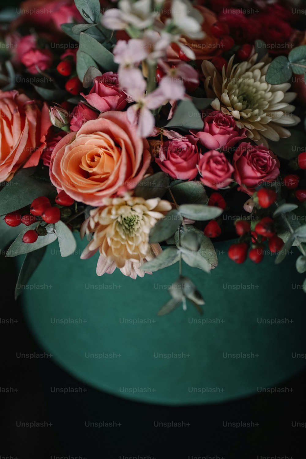 a close up of a vase with flowers on a table