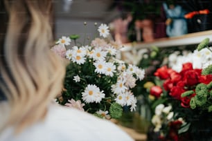 a woman looking at a bunch of flowers