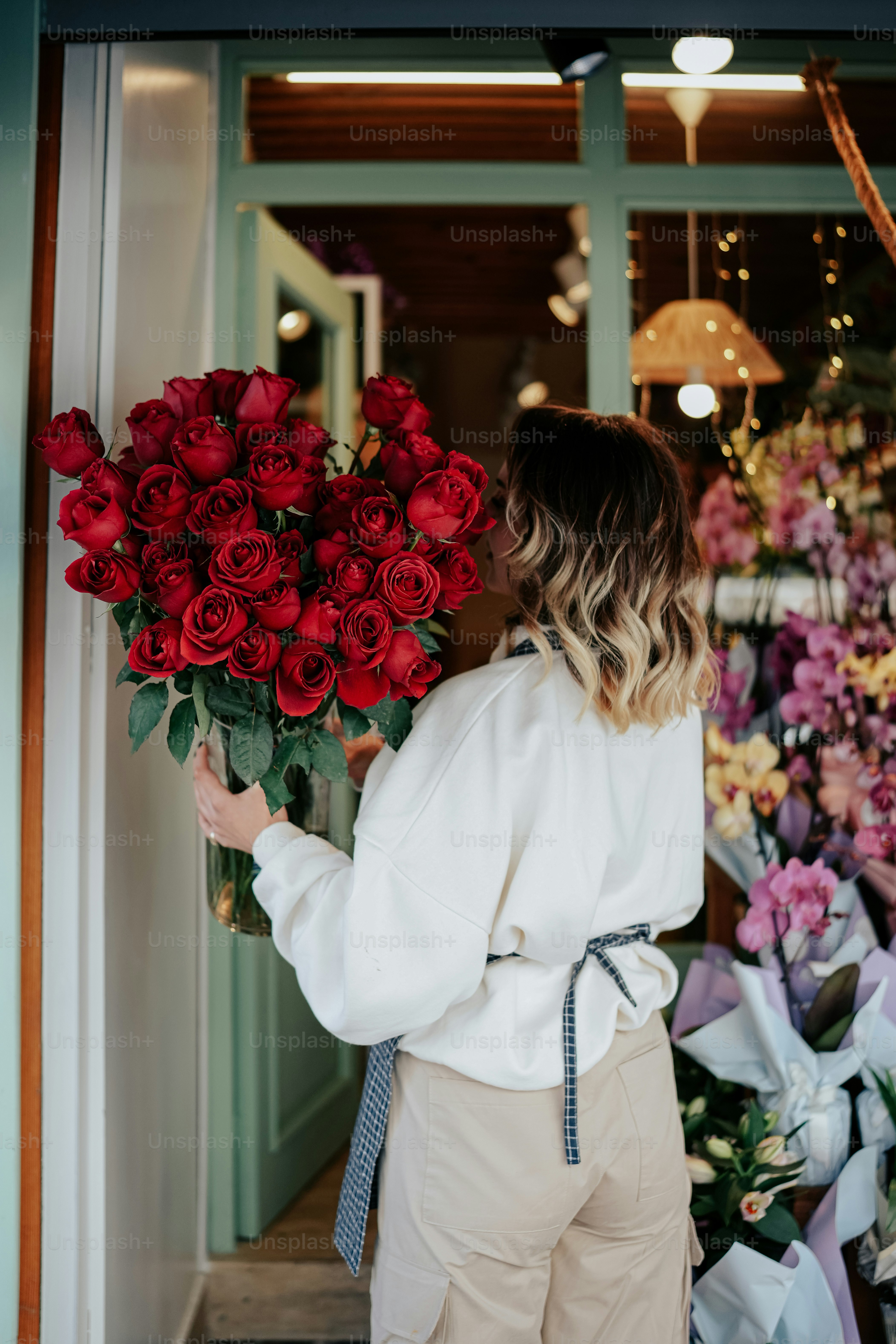 a woman holding a bouquet of red roses