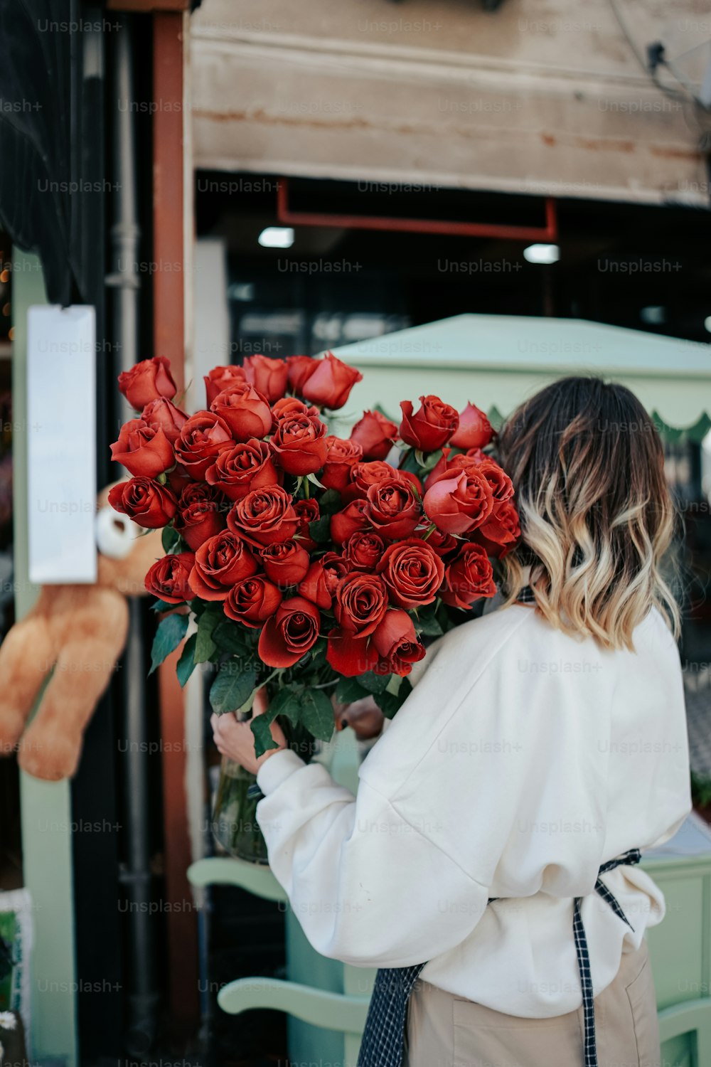 赤いバラの花束を持つ女性