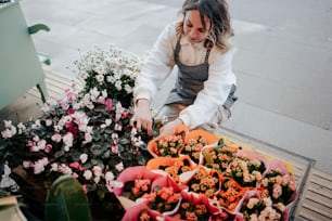 a woman is arranging flowers on a table