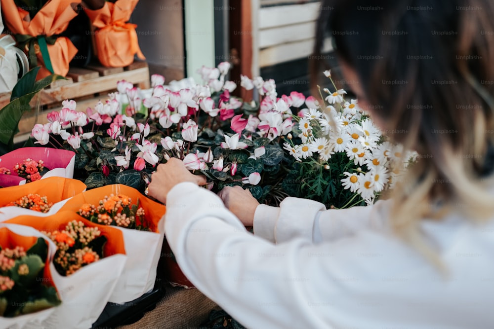 a woman arranging flowers at a flower shop