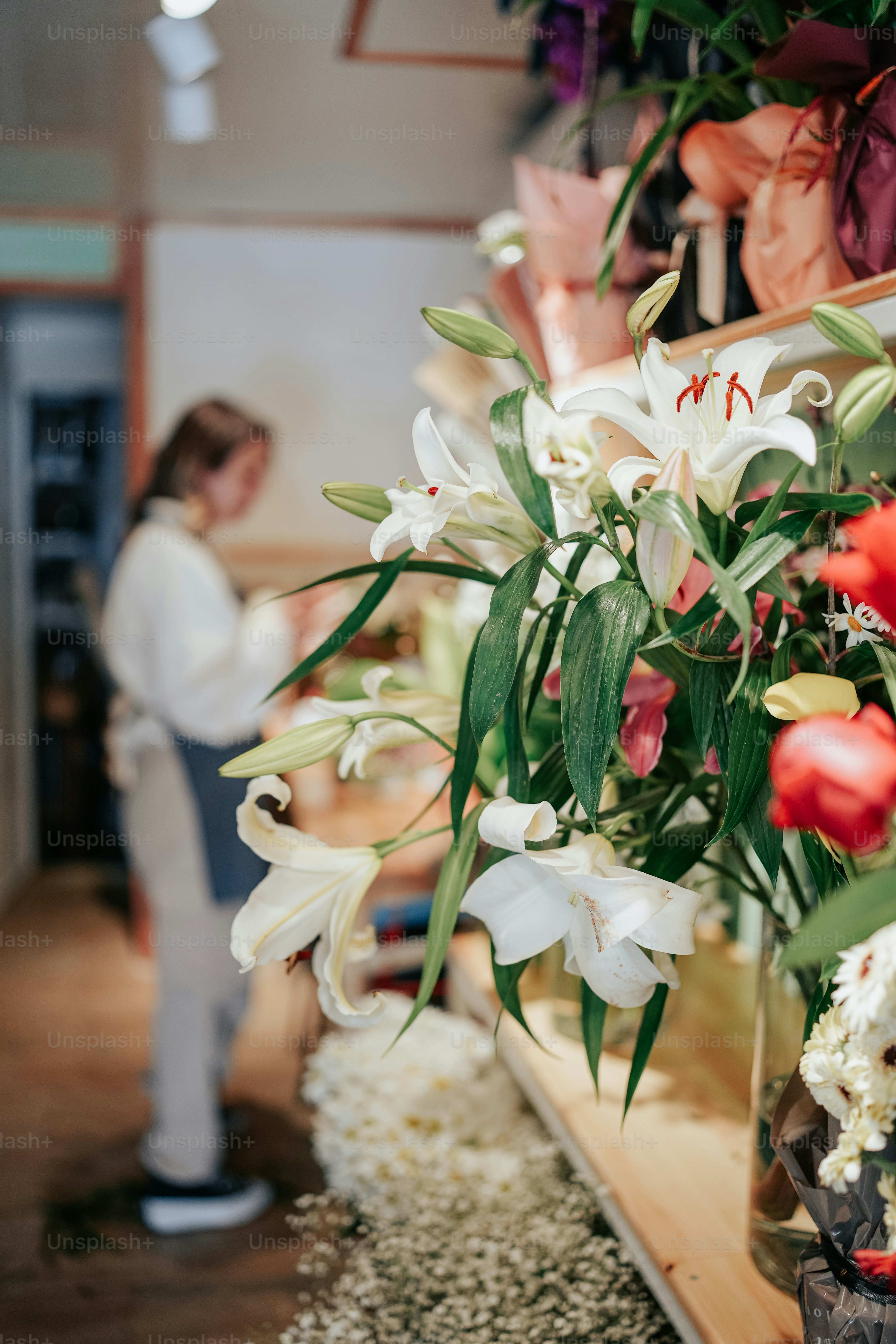 A woman standing in front of a vase filled with flowers photo ...