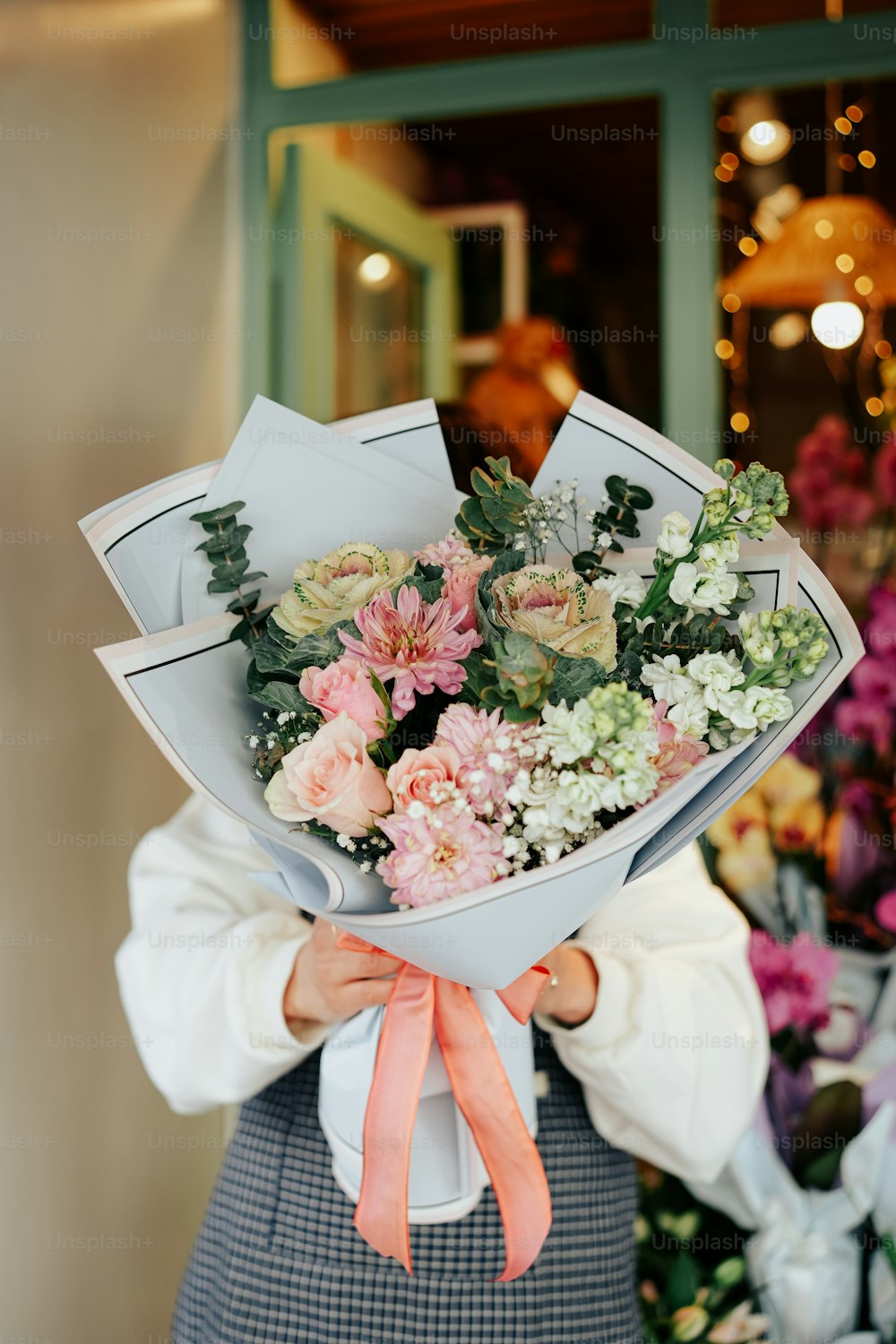 a woman holding a bouquet of flowers in her hands