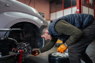 um homem que trabalha em um carro em uma garagem