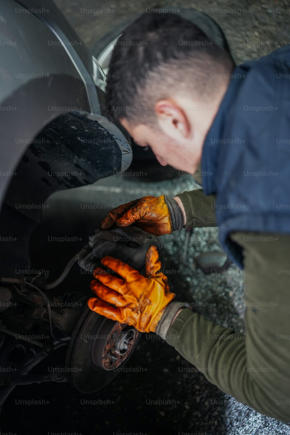 a man working on a car with gloves on