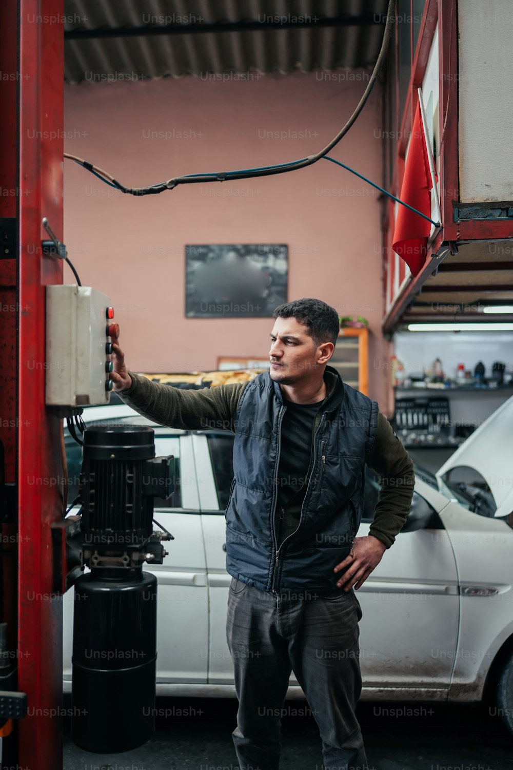 a man standing next to a white car in a garage