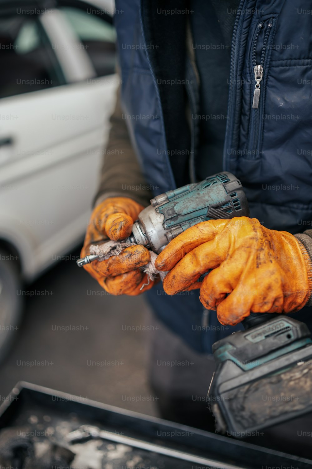 Ein Mann in blauer Jacke hält ein Werkzeug in der Hand