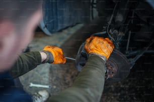 a man working on a vehicle with orange paint