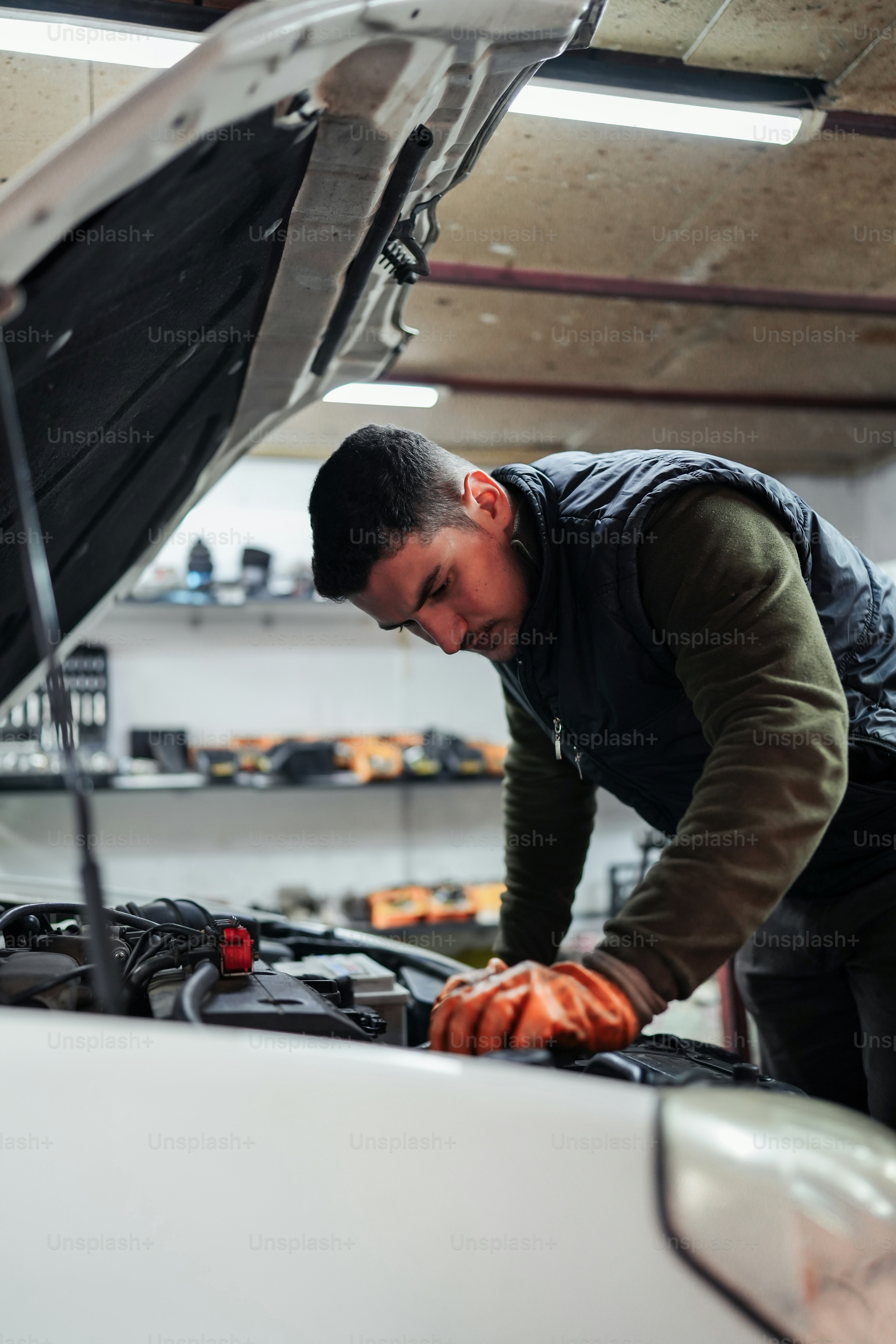 a man working on a car engine in a garage
