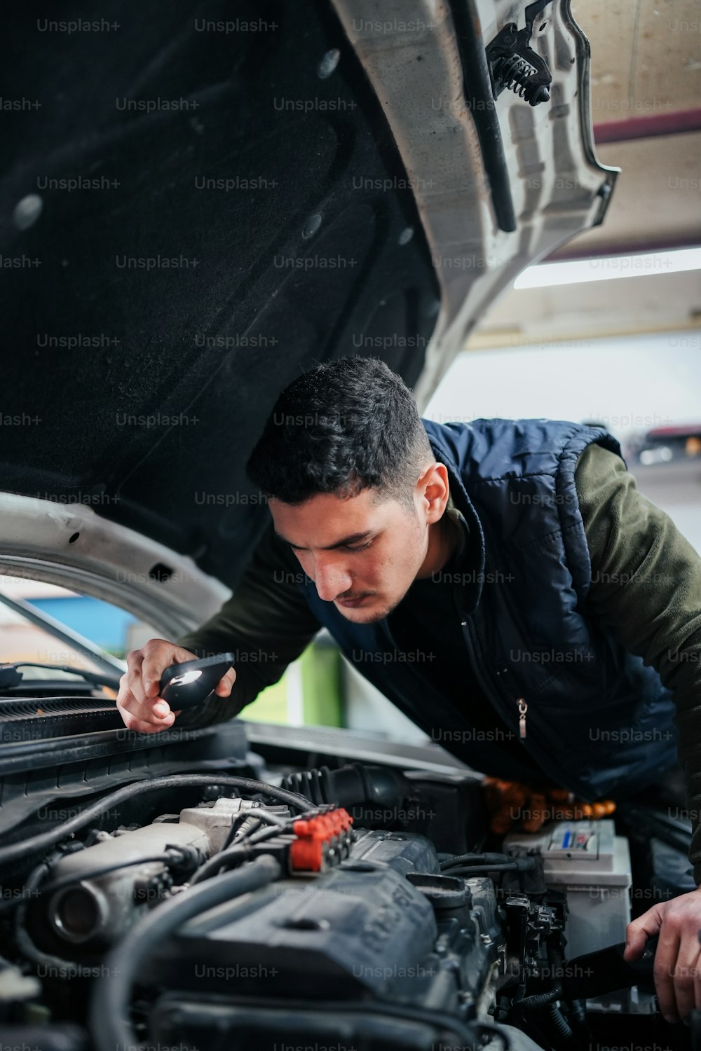 Ein Mann arbeitet an einem Automotor in einer Garage