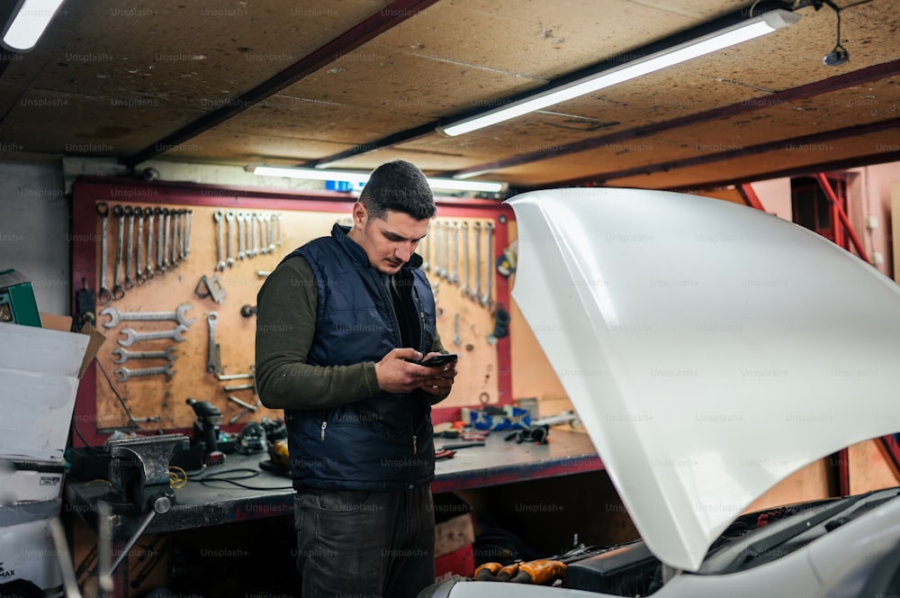 a man in a garage looking at his cell phone