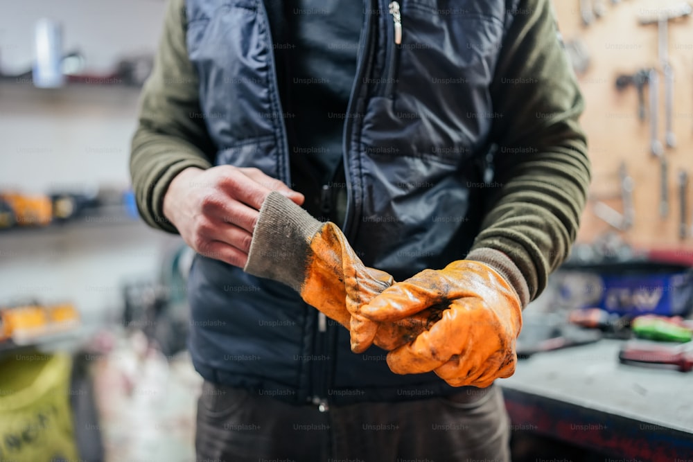 Un homme tenant une paire de gants dans ses mains