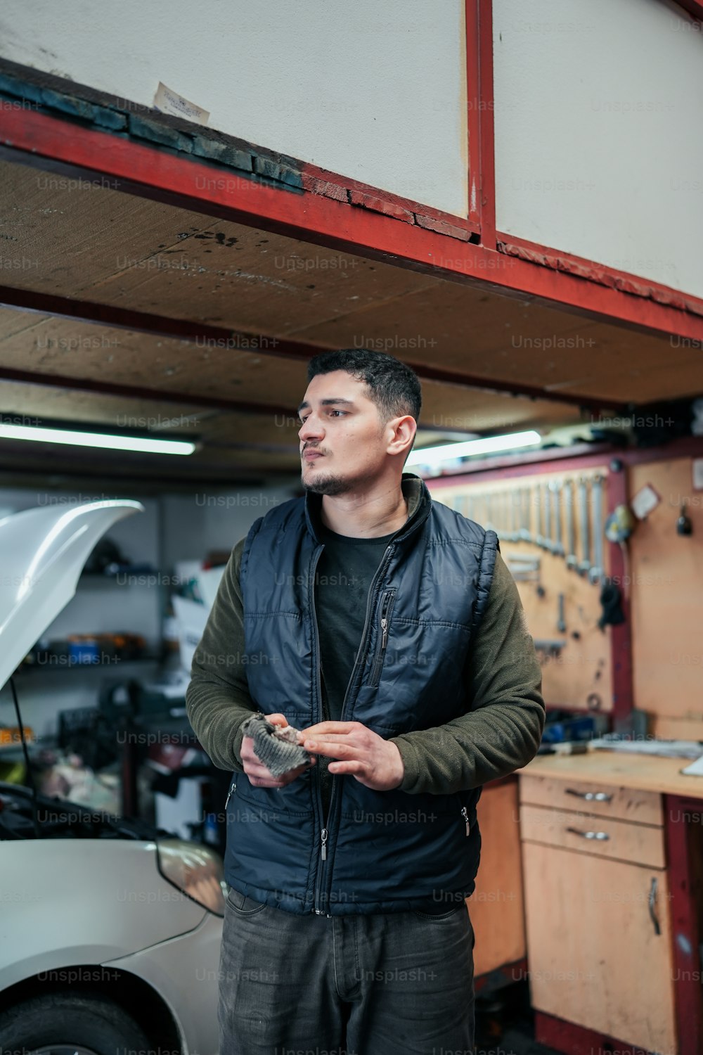 a man standing next to a car in a garage