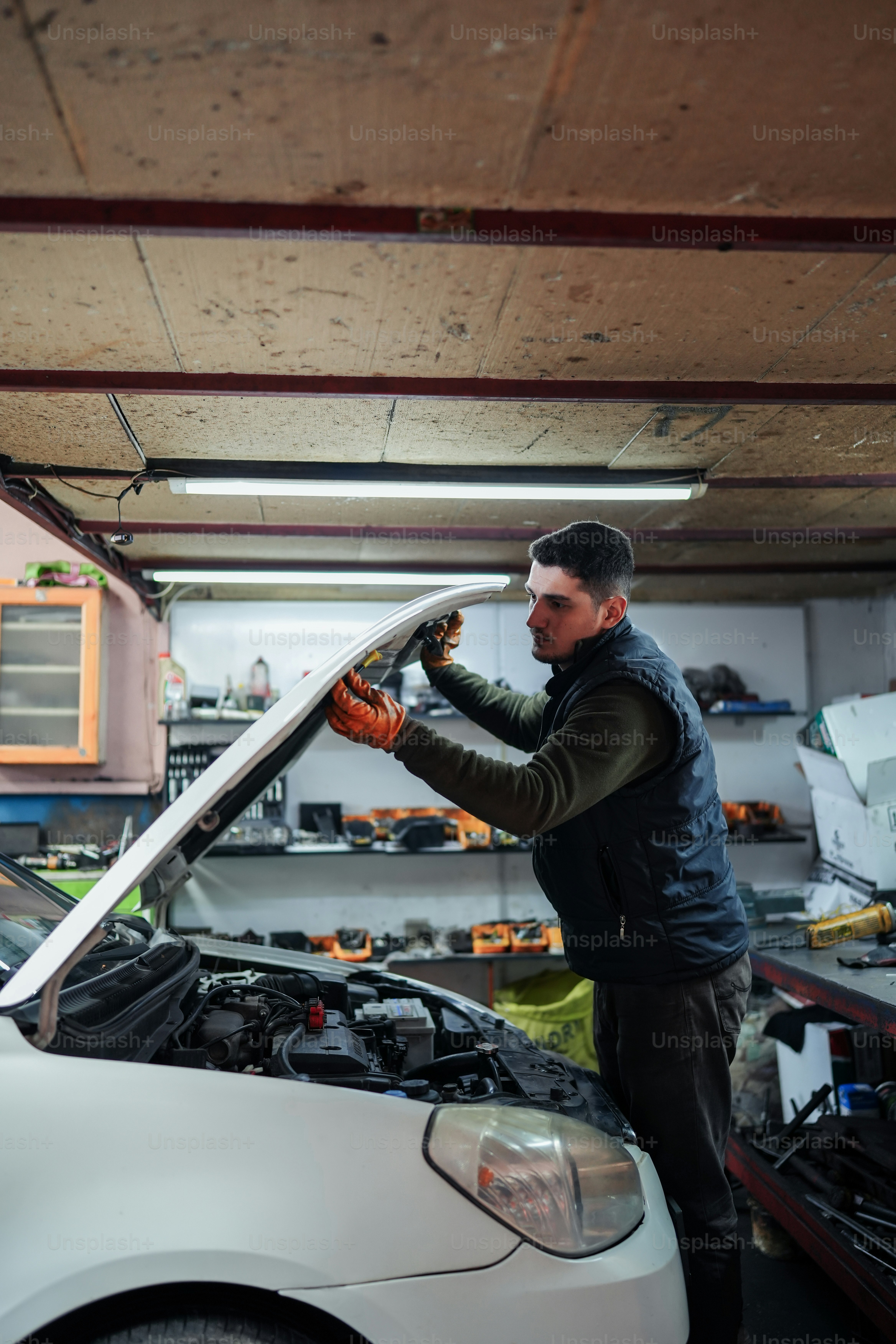 um homem que trabalha em um carro em uma garagem