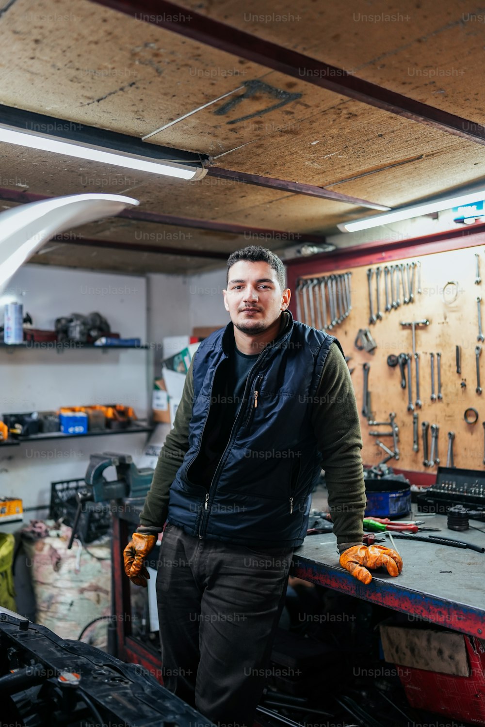 a man standing in a garage next to tools