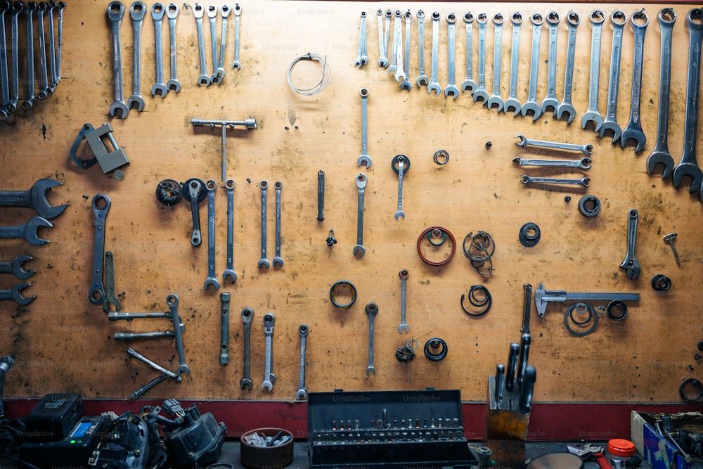 um monte de ferramentas estão penduradas em uma parede