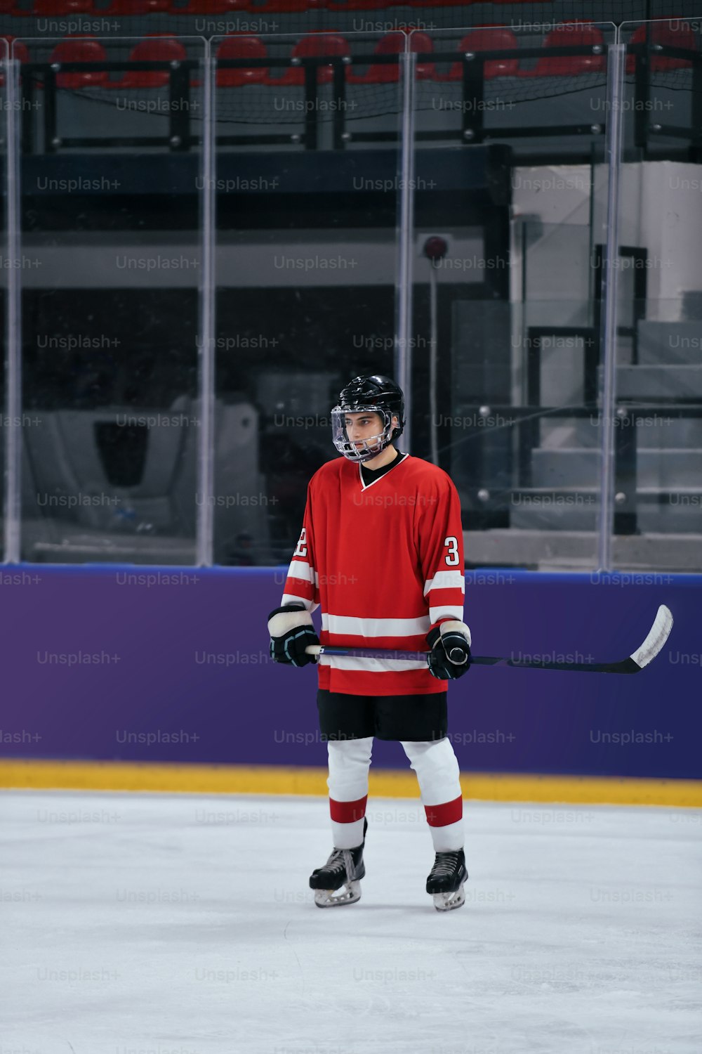 Ein Eishockeyspieler steht mit einem Stock auf dem Eis