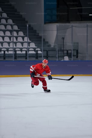 a man in a red hockey uniform playing on an ice rink
