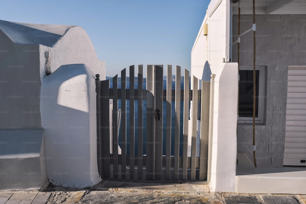 a white house with a wooden gate and a white building