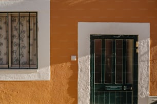 a green door and window on a yellow wall