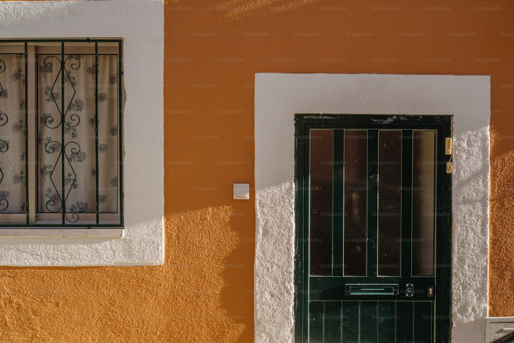 a green door and window on a yellow wall