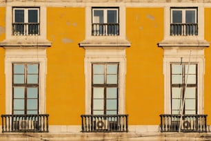a yellow building with windows and balconies