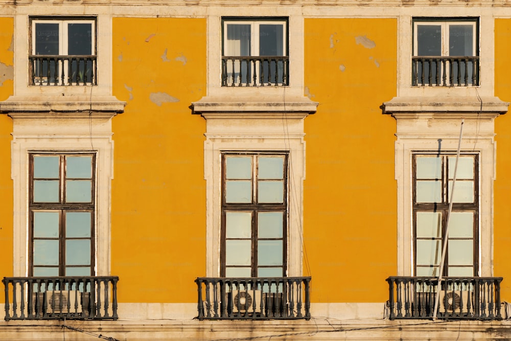 un edificio giallo con finestre e balconi