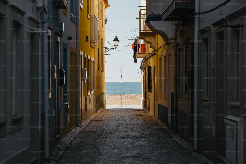 a narrow alley way leading to a beach