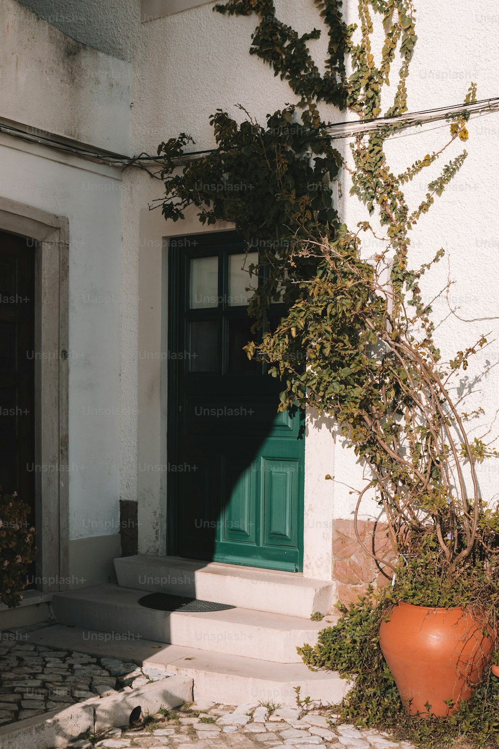 eine grüne Tür auf einem weißen Gebäude mit einer grünen Tür