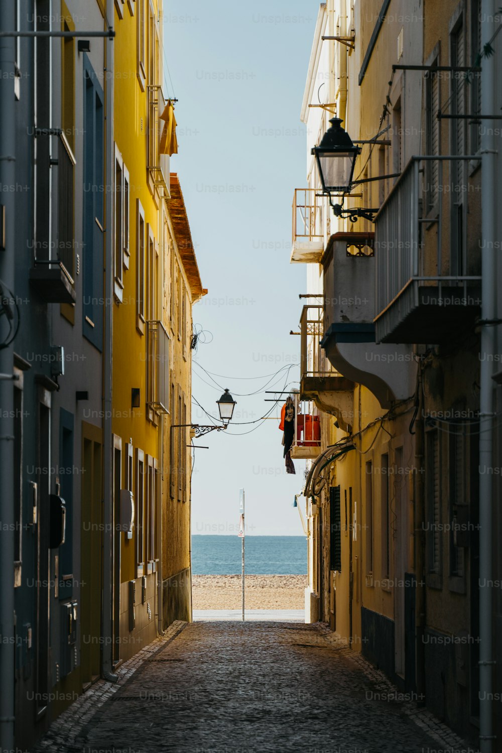 an alley way with a beach in the distance