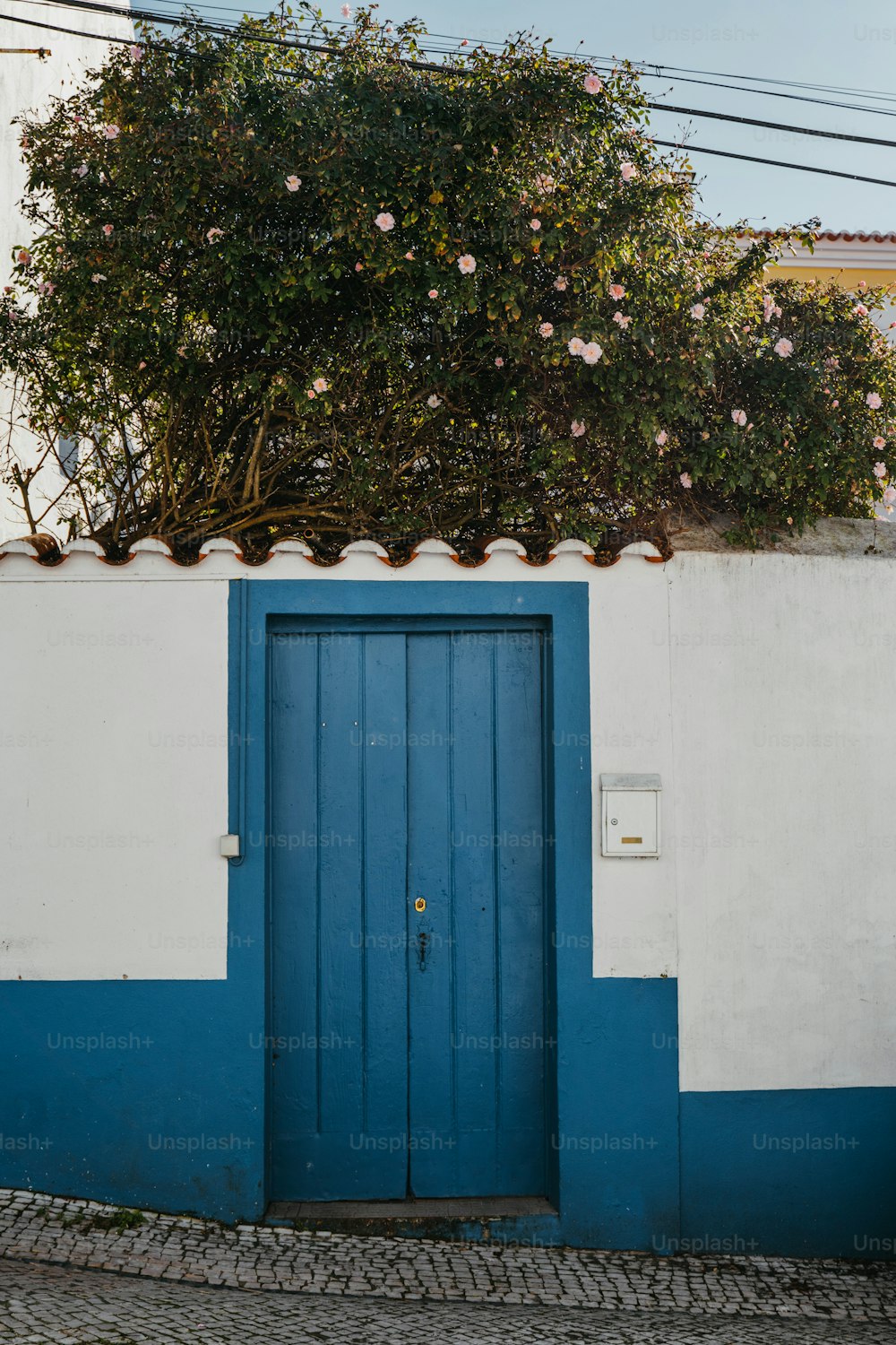 Un edificio azul y blanco con una puerta azul