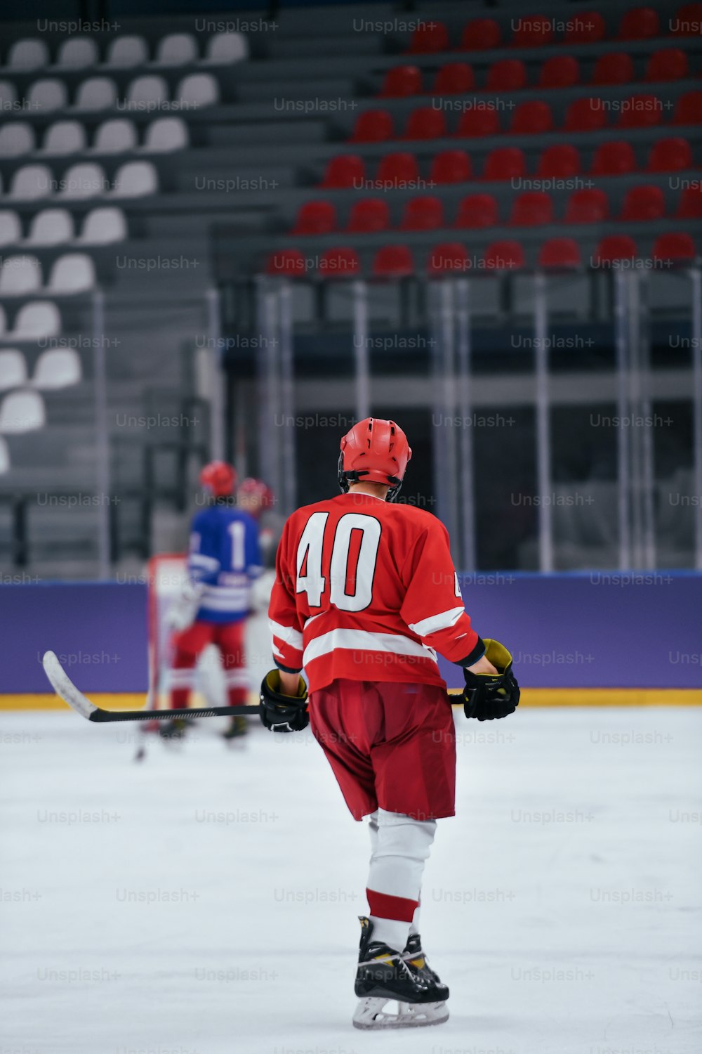 Ein Eishockeyspieler in roter Uniform auf dem Eis