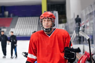 a man in a red hockey uniform holding a hockey stick