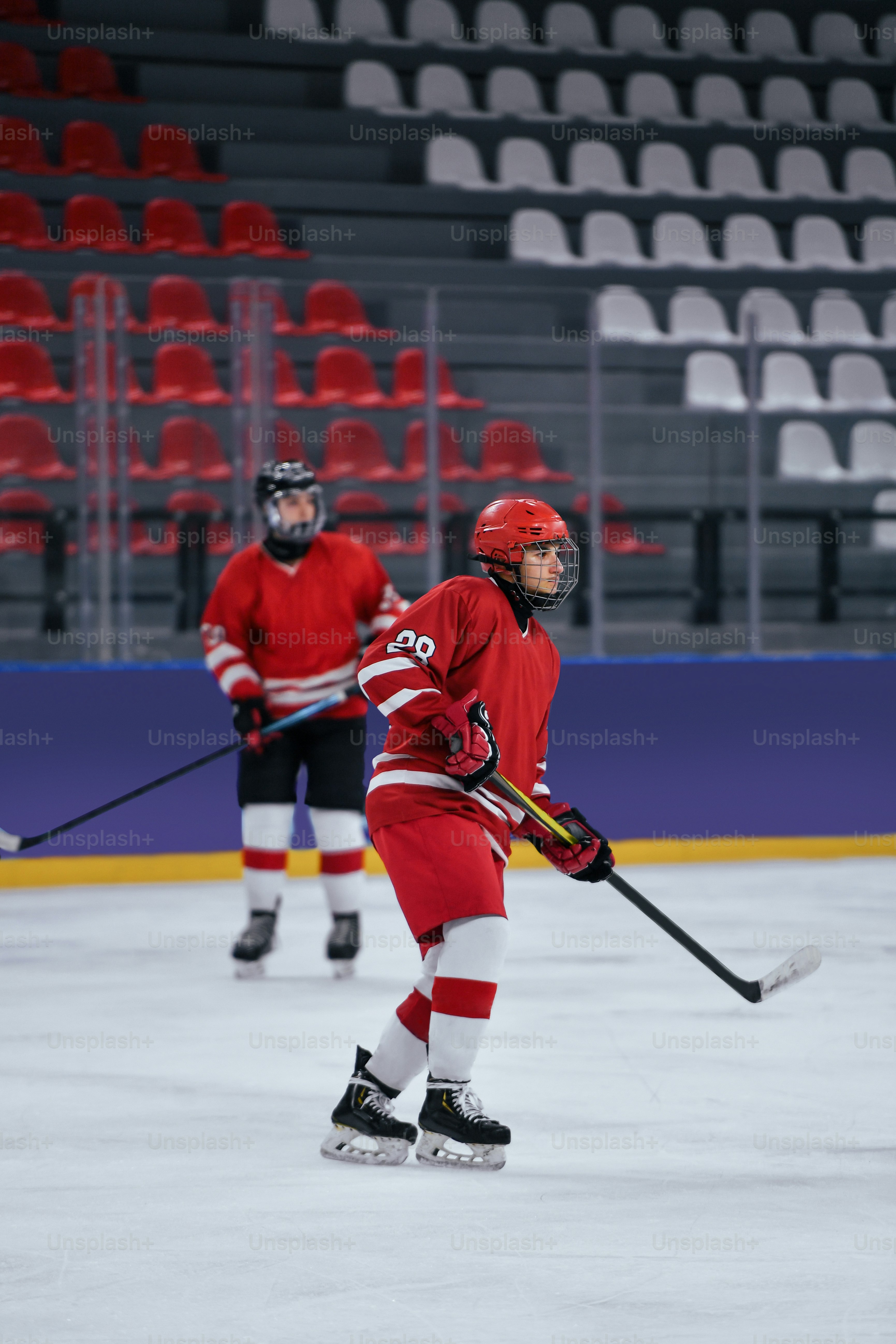 a couple of people playing a game of ice hockey