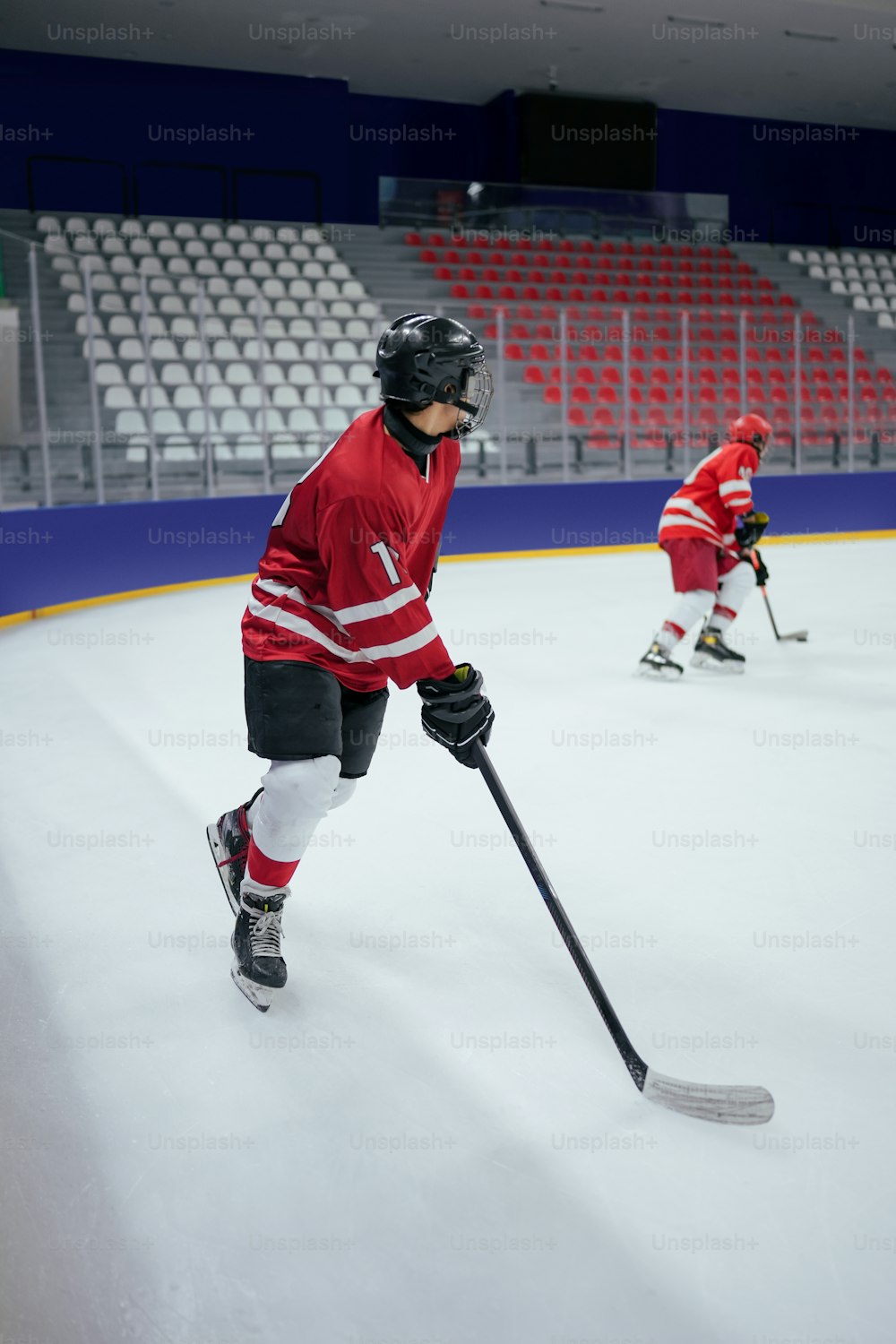 a couple of young men playing a game of ice hockey