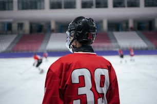 赤いジャージを着たホッケー�選手が氷の上に立つ