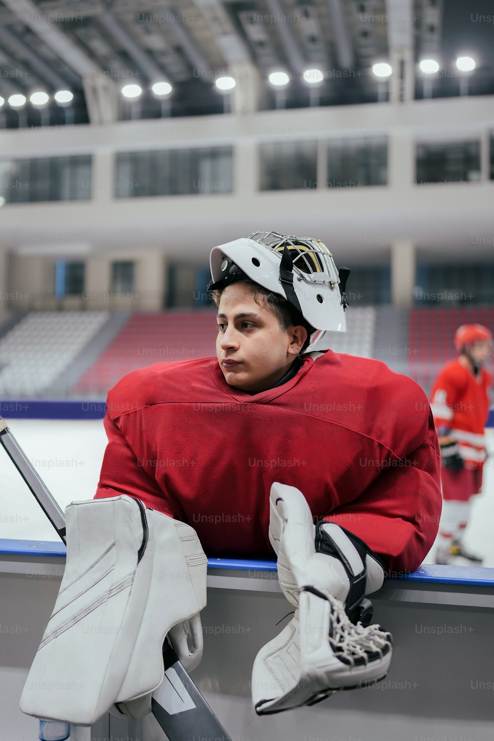a man sitting on a bench with a hockey helmet on