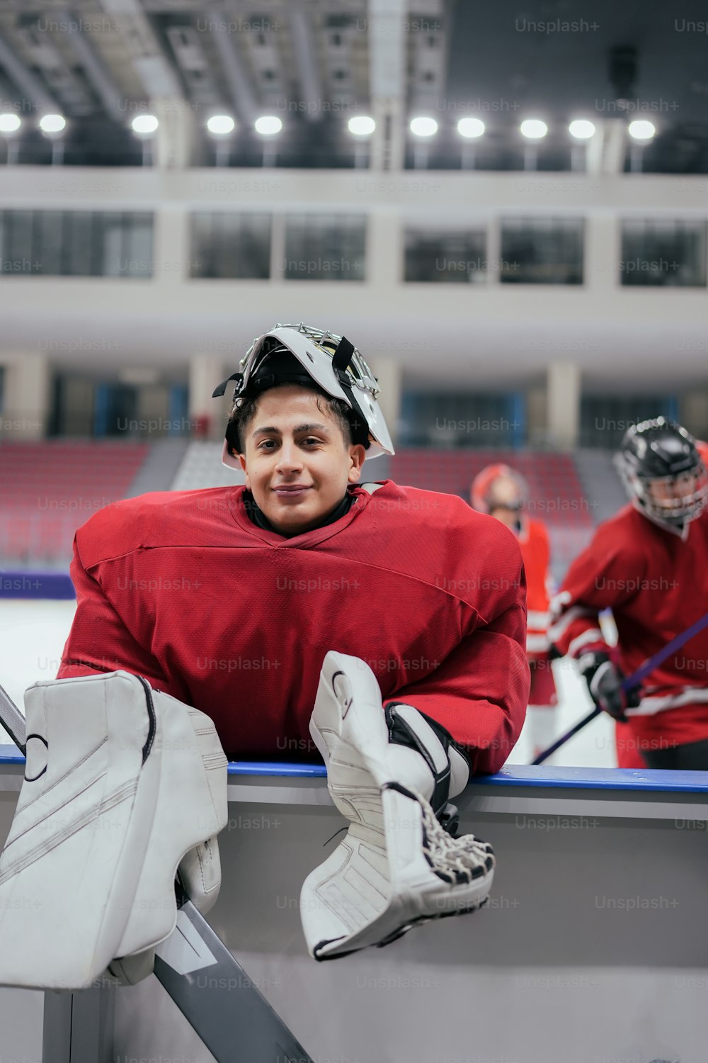 a man in a red jersey sitting on a bench