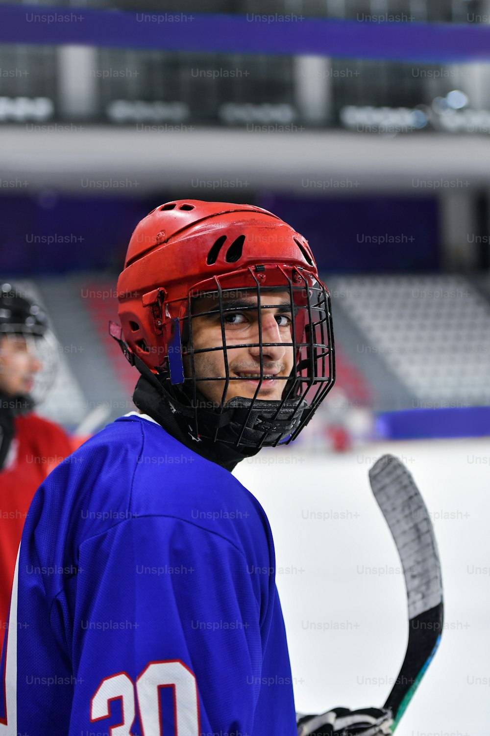 a young man wearing a helmet and holding a hockey stick