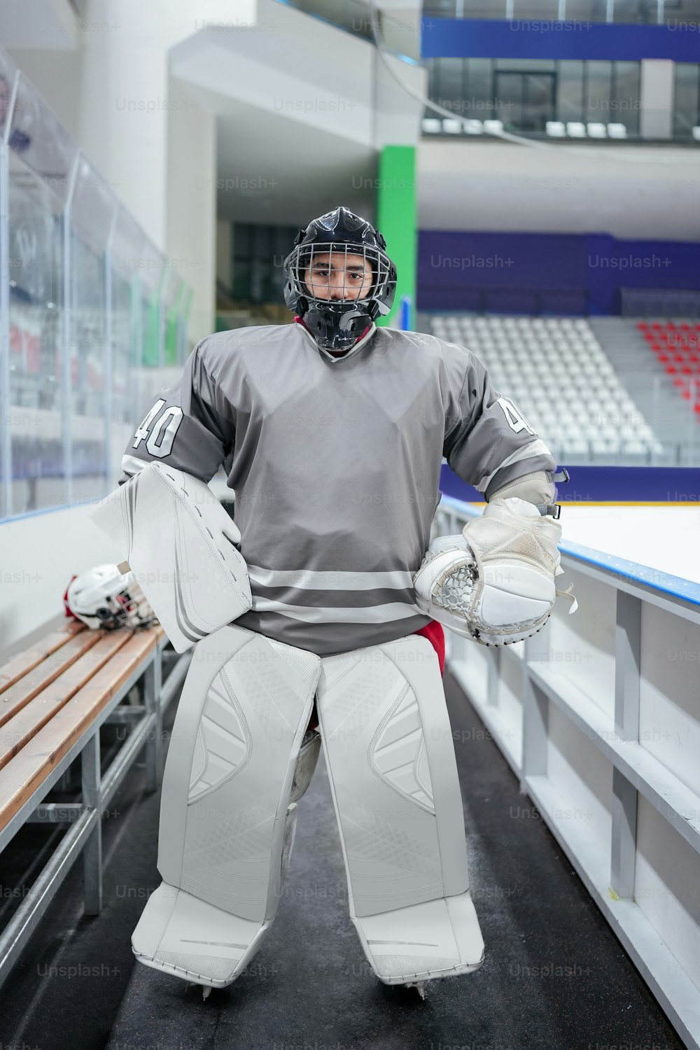 Un homme en costume de gardien de but debout dans une patinoire de hockey