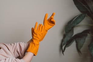 a woman in a pink shirt and yellow gloves